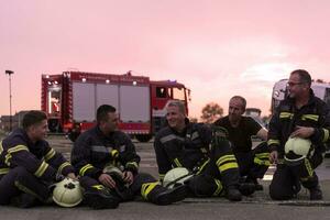 valiente bomberos equipo caminando a el cámara. en antecedentes paramédicos y bomberos rescate equipo lucha fuego en coche accidente, seguro y salvar pueblos vive concepto. foto