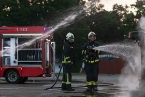 Firefighters fight the fire flame to control fire not to spreading out. Firefighter industrial and public safety concept. Traffic or car accident rescue and help action. photo