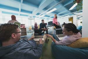 Portrait of young smiling business woman in creative open space coworking startup office. Successful businesswoman standing in office with copyspace. Coworkers working in background. photo