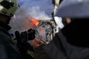 Firefighters fight the fire flame to control fire not to spreading out. Firefighter industrial and public safety concept. Traffic or car accident rescue and help action. photo