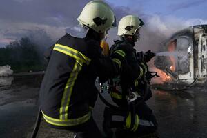 Firefighters using water fire extinguisher to fighting with the fire flame in car accident. Firefighter industrial and public safety concept rescue in night. photo