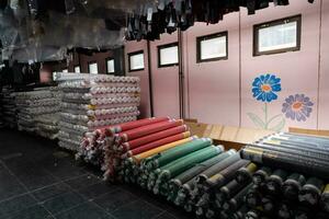 Interior of an industrial warehouse with fabric rolls samples. Small business textile colorful warehouse. photo