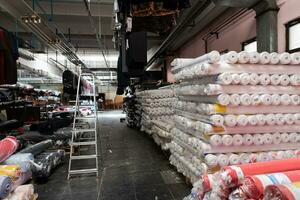 Interior of an industrial warehouse with fabric rolls samples. Small business textile colorful warehouse. photo