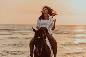 Woman in summer clothes enjoys riding a horse on a beautiful sandy beach at sunset. Selective focus photo