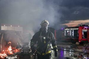 Portrait of a heroic fireman in a protective suit. Firefighter in fire fighting operation. photo