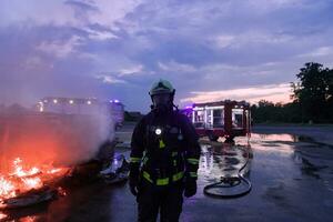 Portrait of a heroic fireman in a protective suit. Firefighter in fire fighting operation. photo