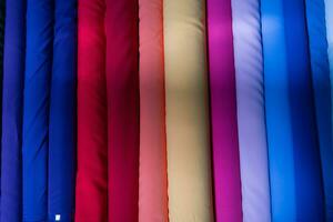 Collection of fashionable fabrics. Samples of different natural fabrics for sewing a fashion collection of clothes. Large selection of fabrics in the store or tailor warehouse. photo