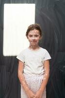 Portrait of a little school girl with chickenpox, antiseptic cream applied to face and body .Colorful background. photo