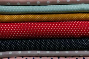 Collection of fashionable fabrics. Samples of different natural fabrics for sewing a fashion collection of clothes. Large selection of fabrics in the store or tailor warehouse. photo