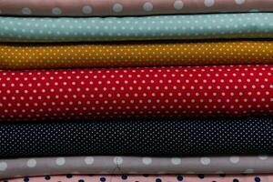 Collection of fashionable fabrics. Samples of different natural fabrics for sewing a fashion collection of clothes. Large selection of fabrics in the store or tailor warehouse. photo