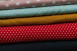 Collection of fashionable fabrics. Samples of different natural fabrics for sewing a fashion collection of clothes. Large selection of fabrics in the store or tailor warehouse. photo