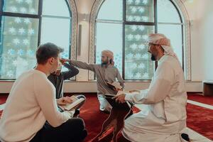 A group of Muslims reading the holy book of the Quran in a modern mosque during the Muslim holiday of Ramadan photo