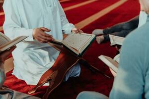 A group of Muslims reading the holy book of the Quran in a modern mosque during the Muslim holiday of Ramadan photo