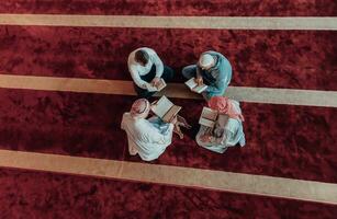 A group of Muslims reading the holy book of the Quran in a modern mosque during the Muslim holiday of Ramadan photo