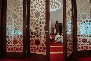 A group of Muslims reading the holy book of the Quran in a modern mosque during the Muslim holiday of Ramadan photo