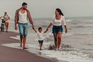 The family enjoys their vacation as they walk the sandy beach with their son. Selective focus photo