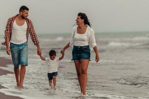 The family enjoys their vacation as they walk the sandy beach with their son. Selective focus photo