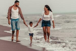 The family enjoys their vacation as they walk the sandy beach with their son. Selective focus photo