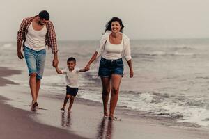 The family enjoys their vacation as they walk the sandy beach with their son. Selective focus photo