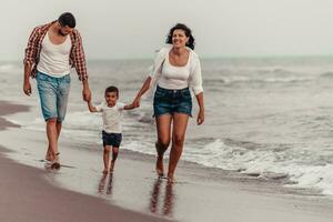 The family enjoys their vacation as they walk the sandy beach with their son. Selective focus photo