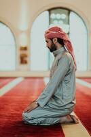 A Muslim praying in a modern mosque during the holy Muslim month of Ramadan photo