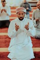 A group of Muslims in a modern mosque praying the Muslim prayer namaz, during the holy month of Ramadan photo