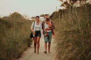 The family walks an idyllic path surrounded by tall grass. Selective focus photo