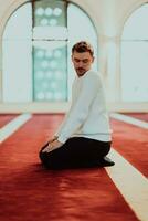 un musulmán Orando en un moderno mezquita durante el santo musulmán mes de Ramadán foto