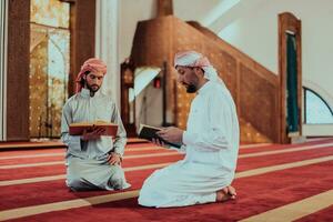 A group of Muslims reading the holy book of the Quran in a modern mosque during the Muslim holiday of Ramadan photo