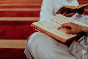 A group of Muslims reading the holy book of the Quran in a modern mosque during the Muslim holiday of Ramadan photo