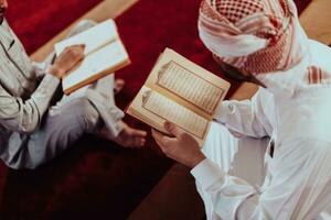 A group of Muslims reading the holy book of the Quran in a modern mosque during the Muslim holiday of Ramadan photo