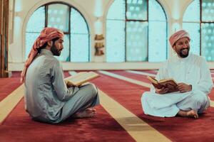 A group of Muslims reading the holy book of the Quran in a modern mosque during the Muslim holiday of Ramadan photo