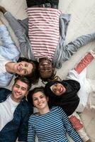 Top view of a diverse group of people lying on the floor and symbolizing togetherness photo