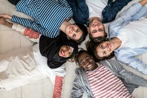 Top view of a diverse group of people lying on the floor and symbolizing togetherness photo