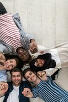 Top view of a diverse group of people lying on the floor and symbolizing togetherness photo