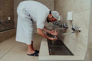 A Muslim performing ablution. Ritual religious cleansing of Muslims before performing prayer. The process of cleansing the body before prayer photo