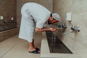 A Muslim performing ablution. Ritual religious cleansing of Muslims before performing prayer. The process of cleansing the body before prayer photo