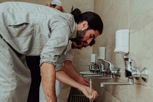 A Muslim performing ablution. Ritual religious cleansing of Muslims before performing prayer. The process of cleansing the body before prayer photo