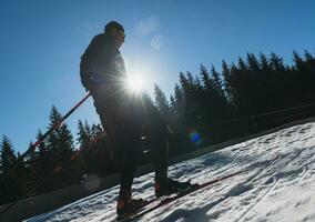 Nordic skiing or Cross-country skiing classic technique practiced by man in a beautiful panoramic trail at morning. photo