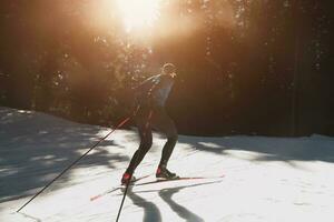 Nordic skiing or Cross-country skiing classic technique practiced by man in a beautiful panoramic trail at morning. photo