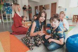 un niña y un chico con abajo síndrome en cada otros brazos gastar hora juntos en un preescolar institución foto