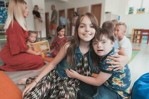 A girl and a boy with Down's syndrome in each other's arms spend time together in a preschool institution photo