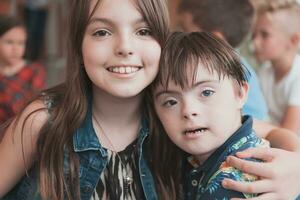 A girl and a boy with Down's syndrome in each other's arms spend time together in a preschool institution photo