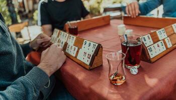 A group of men drink traditional Turkish tea and play a Turkish game called Okey photo