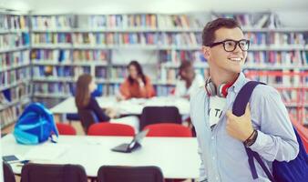 the student uses a notebook, latop and a school library photo