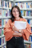 the student uses a notebook and a school library photo