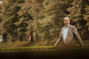 Focused businessman in a suit walking in the park photo