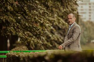 Focused businessman in a suit walking in the park photo