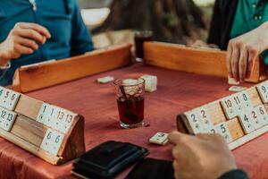 A group of men drink traditional Turkish tea and play a Turkish game called Okey photo