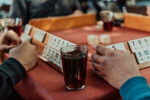 A group of men drink traditional Turkish tea and play a Turkish game called Okey photo